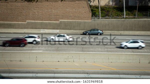 Car\
stranded on shoulder of freeway with tow truck stopped behind it\
and traffic blurred as cars speed by the\
scene