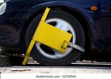 Car Street Clamped With Yellow Metal Wheel Clamp