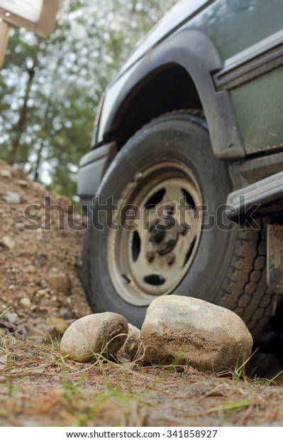 Car stuck in forest, selective focus cropped\
shot. Vertical composition.