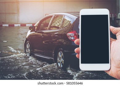 Car Stuck In Mud And Splash, Concept Of Natural Disaster Flood And Smartphone, People Need Help From Network And The Internet.