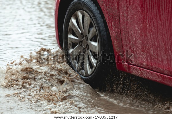 Car stuck in the mud, car wheel in a dirty\
puddle, rough terrain