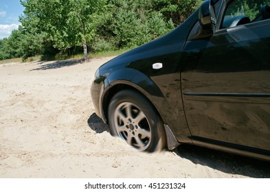 Car Stuck In The Sand On Background Of Green Trees