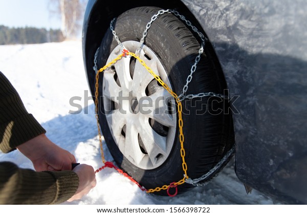 Car stuck in the snow drift. Tire fitted with\
snow chains.