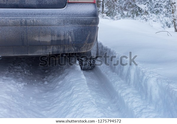 car stuck in the snow\
in a snowy forest