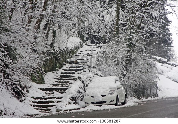 car
submerged by snow and a stair leading up to the
Hill