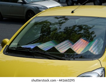 The Car With Sun Shade On The Windshield In A Parking Lot. Folding Holographic Sunshade.