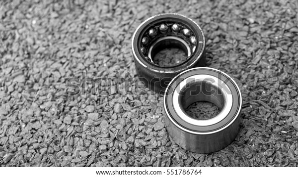 Car Suspension and car bearing parts concept -\
New wheels car bearing and old wheels car bearing on asphalt floor\
in garage and copyspace