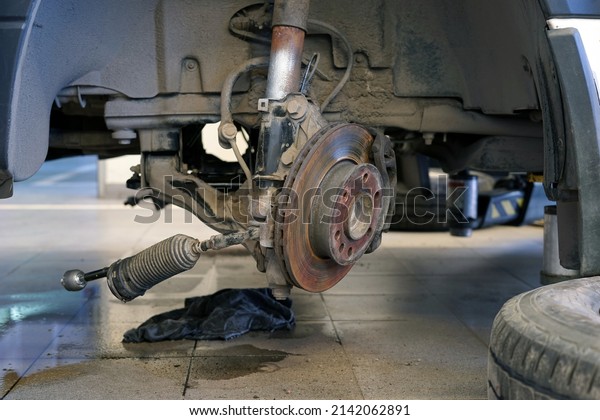 Car suspension repair in a modern car\
service. The wheel was removed from the car and the suspension and\
steering were partially\
disassembled.