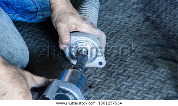 Car suspension and shock up\
absorber service concept - Close up hand of mechanic man seting\
shock up absorber for car suspension service in auto garage and\
copy space