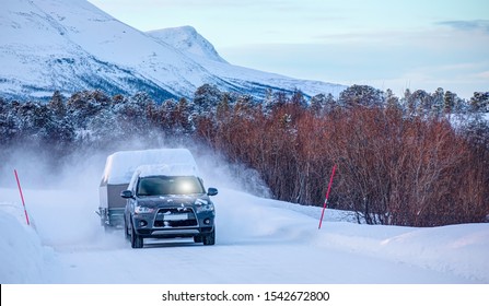  Car (SUV) Moving On Snowy Road  With Small Trailer At The Winter 