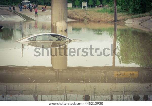 Car swamped by flood water near Buffalo Bayou Park
in Houston, Texas. Flooded car under deep water on a heavy high
water road. Disaster Motor Vehicle Insurance Claim Themed.Severe
weather,vintage look