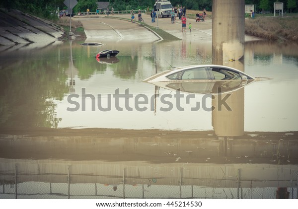 Car swamped by flood water near Buffalo Bayou Park\
in Houston, Texas. Flooded car under deep water on a heavy high\
water road. Disaster Motor Vehicle Insurance Claim Themed.Severe\
weather,vintage look