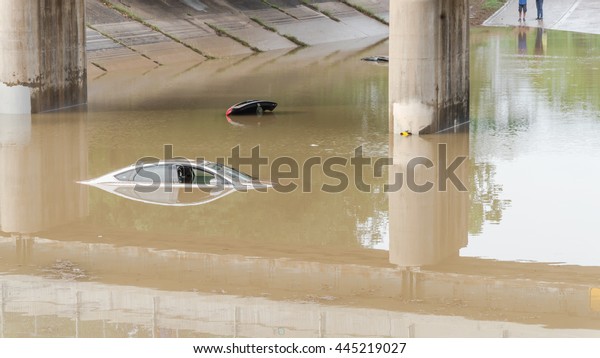 Car swamped by flood water near Buffalo Bayou
Park in Houston, Texas. Flooded car under deep water on a heavy
high water road. Disaster Motor Vehicle Insurance Claim Themed.
Severe weather, panorama.