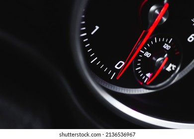 Car tachometer with glowing red indicators closeup view, of luxury dashboard in sport car