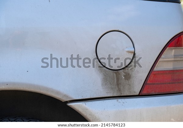 Car tank cap with fuel leaks. Fuel leaks below the
car's tank cap