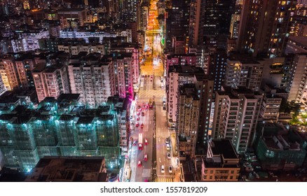 Car, Taxi, And Bus Traffic On Road Intersection At Night In Hong Kong Downtown District, Drone Aerial Top View. Street Commuter, Asia City Life, Or Public Transportation Concept