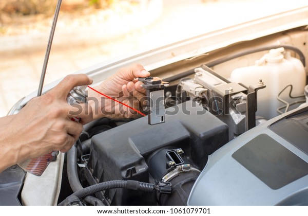  Car\
technician hand  checking and maintenance the air flow sensor  with\
spray cleanser in auto repair\
service.