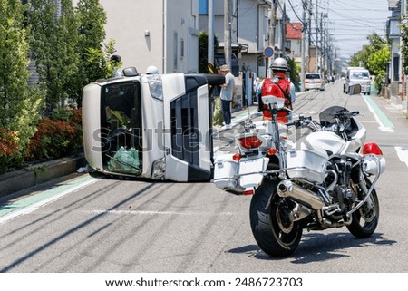 A car that collided at an intersection and overturned and a police's motorcycle