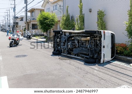 A car that collided at an intersection and overturned and a police's motorcycle