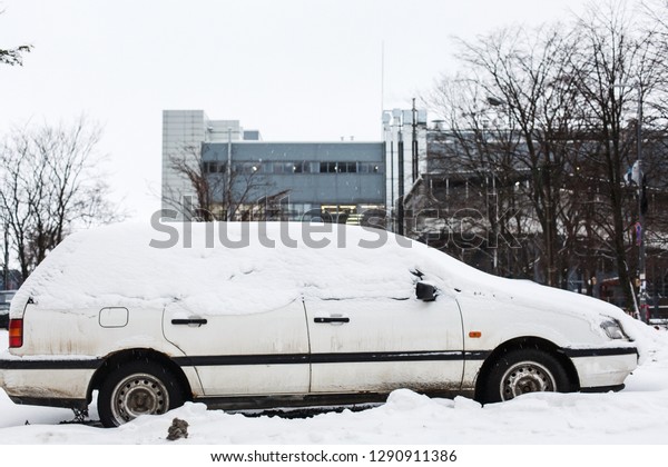 \
A car that snowed at night. Snow on a car after a\
heavy snowfall in winter, which must be cleaned of snow for a long\
time.