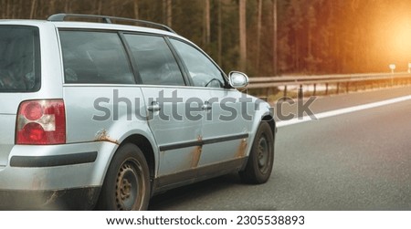 Car that started rusting. European old car on the highway. Rusty vehicle. Weathered car body that needs welding and paint job.
