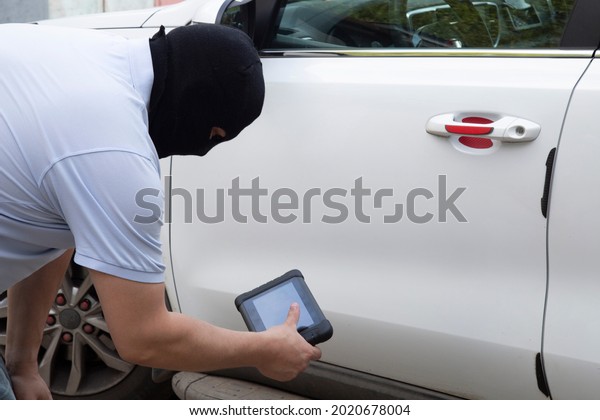 Car theft. The hijacker is trying to steal a car in\
the parking lot.