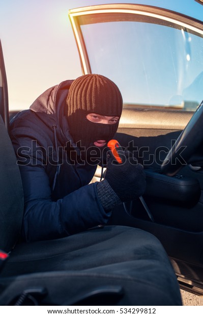 Car theft opening door using screwdriver. Auto\
theft concept.