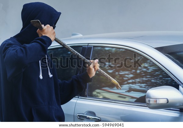 Car\
thief holding a crowbar to hit a window at car\
park