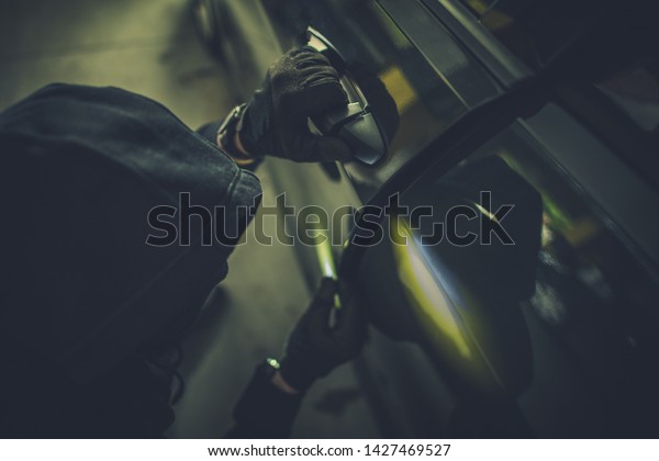 Car Thief Opening Modern Car\
Doors and Going to Steal the Car. Grand Theft Auto Concept\
Photo.