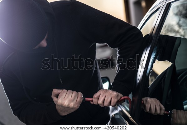Car Thief tries to break into car with crowbar. Car\
thief, car theft