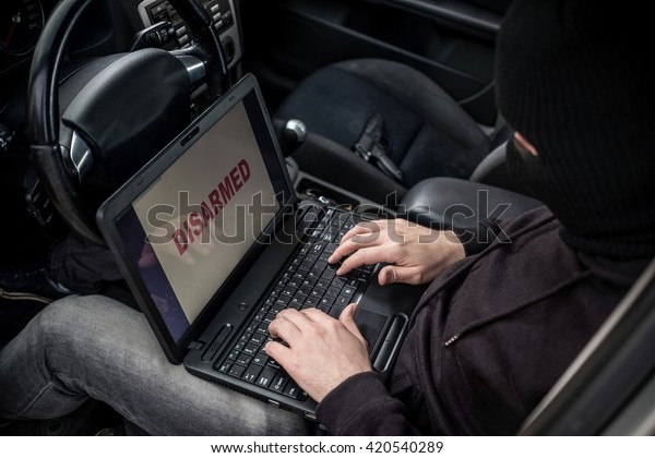 Car Thief tries to\
disarm car security systems and immobiliser with laptop computer.\
Car thief, car theft