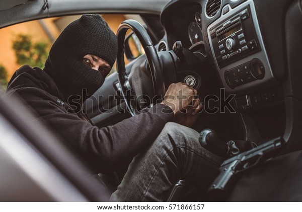 Car thief trying to start car with screwdriver\
in ignition. Car thief, car\
theft