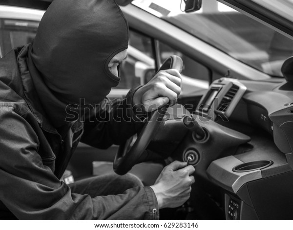 Car thief trying to start car with screwdriver\
in ignition. Car thief, car\
theft