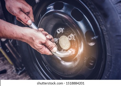 Car Tire Change, Hands On Wrench Closing Screws After Changing Flat Tire