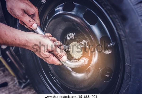 car tire change, hands on wrench closing screws\
after changing flat tire