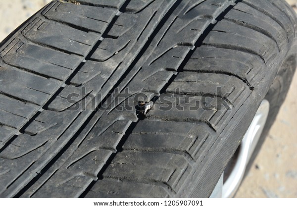 Car tire damage\
with nail. Flat car tire.