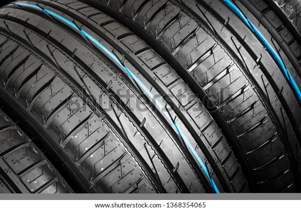Car tire isolated on\
black background. Tire stack. Car tyre protector close up. Black\
rubber tire. Brand new car tires. Close up black tyre profile. Car\
tires in a row