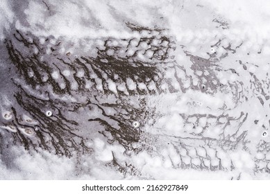 Car Tire Marks On Wet Pavement On Soapy White Foam From Detergents At A Car Wash. Texture Background.