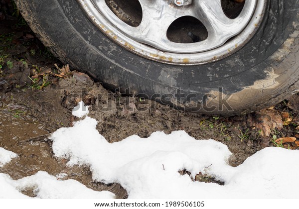 Car tire in the mud in\
winter.