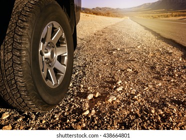 Car tire on dirt road at sunset time