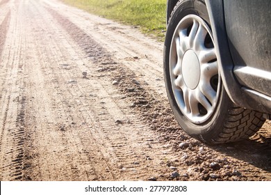 Car Tire On Gravel Road In Evening Light