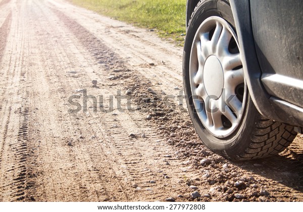 car tire on gravel\
road in evening light