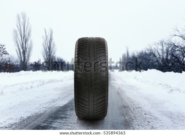 Car tire on road.\
Winter tires concept.