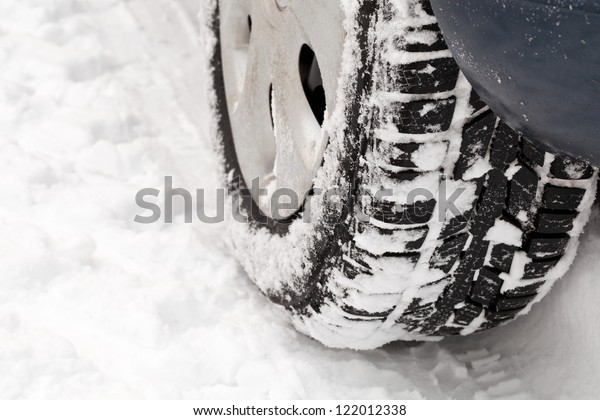 Car tire on snowy road close\
up