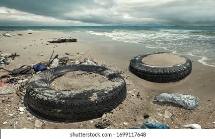 Car Tire And Plastic Bottles Pollution In Muddy Puddle On Beach. (Environment Concept)