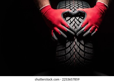 Car tire service and hands of mechanic holding new tyre on black background with copy space for text - Powered by Shutterstock