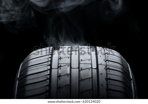 Car tire and smoke on\
black background