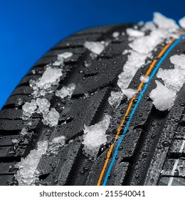 car tire with snow in winter on blue background