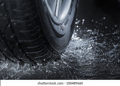 Car Tire Splashing In Water.