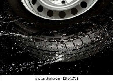 Car Tire Splashing In Water, Tire With Water.